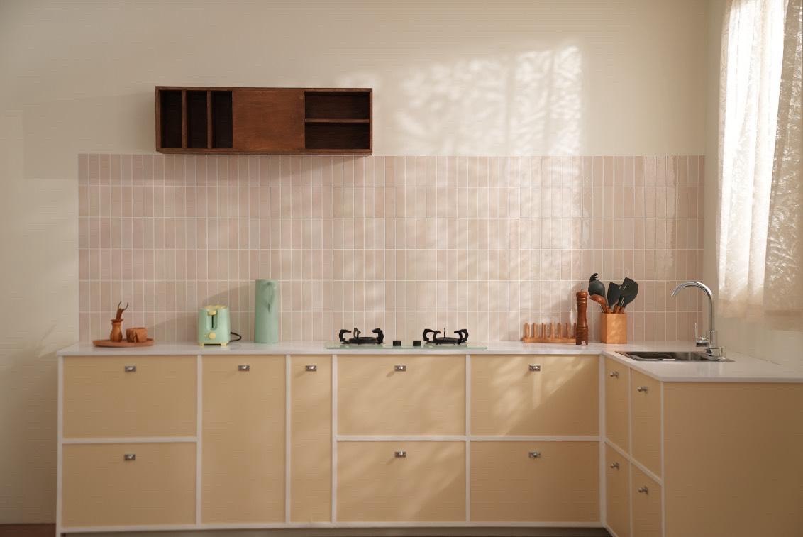 Studio kitchen: butter-yellow cabinets and pale pink tiles